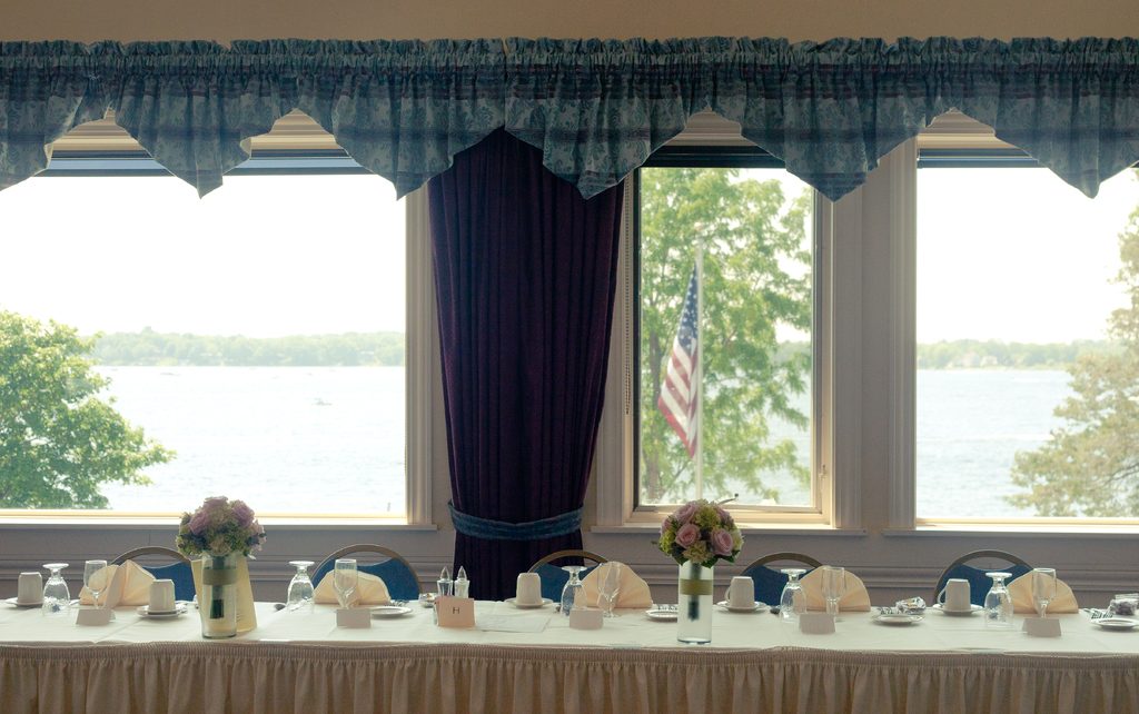A row of large windows looking out over a lake from a bright dining room
